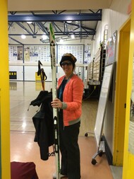 Teacher carrying ski equipment at gym