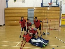 Students playing floor hockey at gym