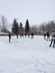 Students playing hockey outside in winter